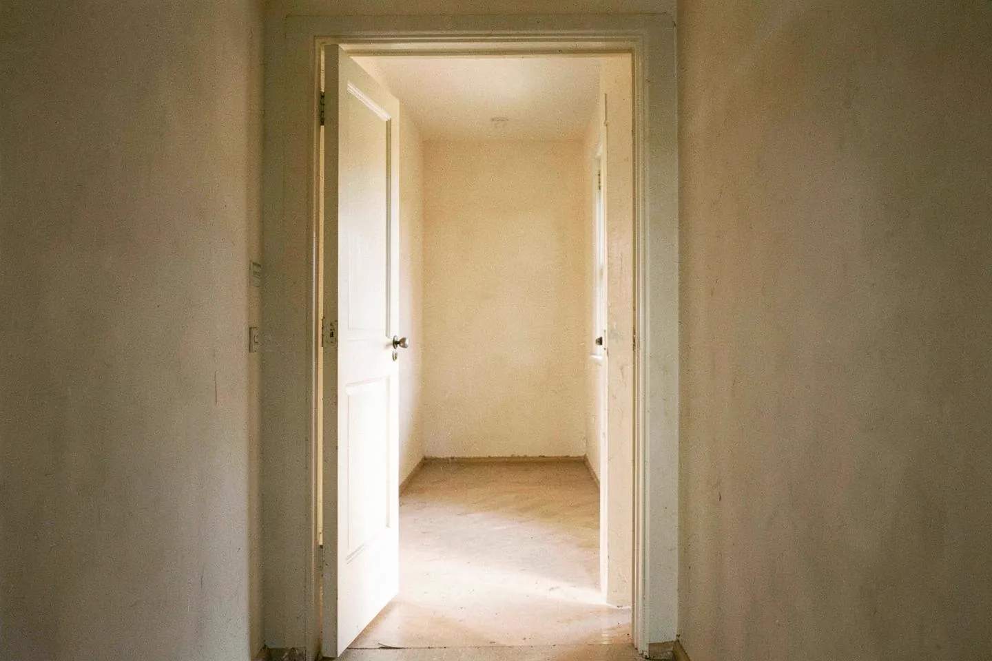 A partly open door with daylight spilling through